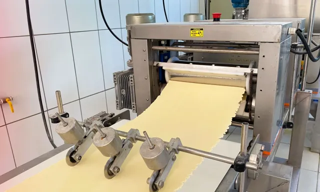 Massa saindo da laminadora na fábrica